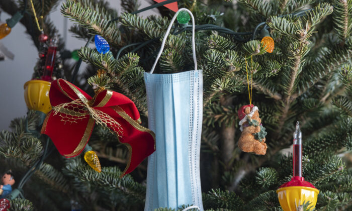 A surgical face mask hangs from a Christmas tree in Montreal on Dec. 24, 2021. (Graham Hughes/The Canadian Press)