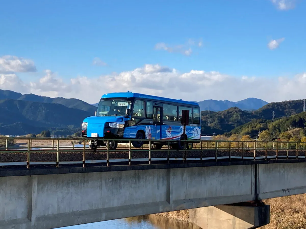 A 'Dual-Mode Vehicle (DMV)' bus that can run both on conventional road surfaces and a railway track, is seen during its test run in Kaiyo Town, Tokushima Prefectue, Japan, on Dec. 24, 2021. (Tokushima Prefectural Government/Handout via Reuters)