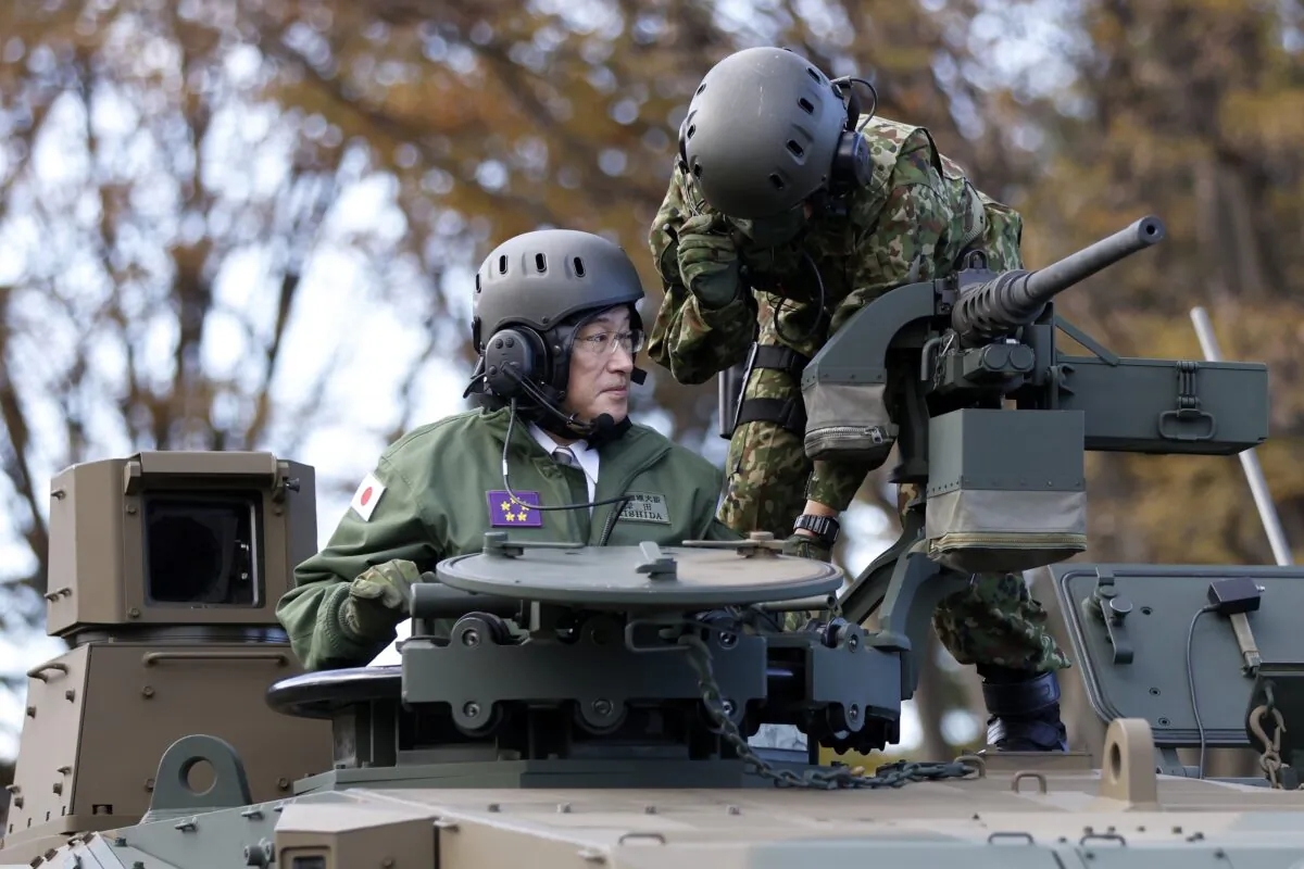 Japan's Prime Minister Fumio Kishida (L) rides on a Japan Ground Self-Defense Force (JGSDF) Type 10 tank during a review at the JGSDF Camp Asaka in Tokyo on Nov. 27, 2021. (Kiyoshi Ota/Pool Photo via AP)