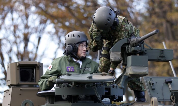 Japan's Prime Minister Fumio Kishida (L) rides on a Japan Ground Self-Defense Force (JGSDF) Type 10 tank during a review at the JGSDF Camp Asaka in Tokyo on Nov. 27, 2021. (Kiyoshi Ota/Pool Photo via AP)