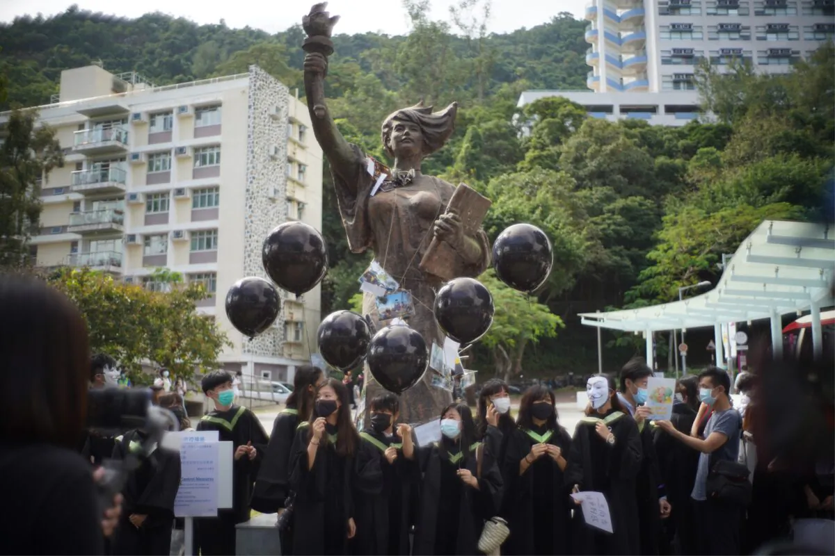Students from the Chinese University of Hong Kong (CUHK) hold black balloons and placards as they gather at the statue of the "Goddess of Democracy" at a protest on campus in memory of the pro-democracy demonstrations at CUHK a year ago, during graduation festivities in the Shatin area of Hong Kong on November 19, 2020. (Photo by Yan ZHAO / AFP) (Photo by YAN ZHAO/AFP via Getty Images)