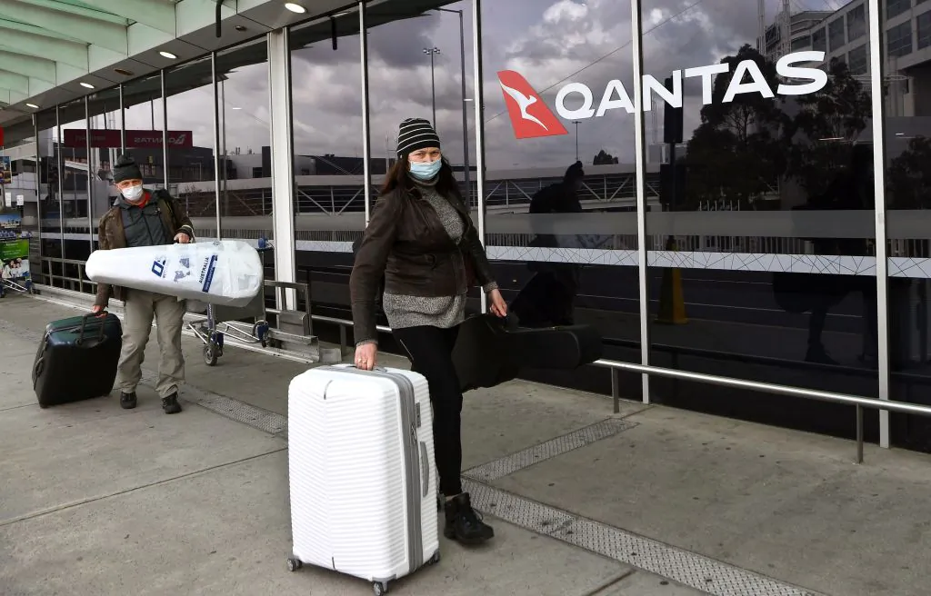 Travellers arrive at a deserted Qantas terminal at Melbourne Airport in Melbourne, Australia, on August 26, 2021 (William West/AFP via Getty Images)