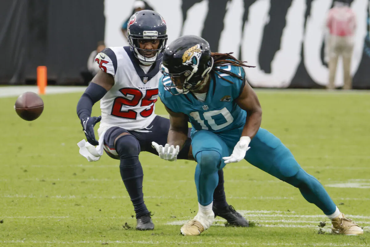 A pass slips through the hands of Jacksonville Jaguars wide receiver Laviska Shenault Jr. (10) as he is defended by Houston Texans cornerback Desmond King (25), during an NFL game in Jacksonville, Fla., on Dec. 19, 2021. (Stephen B. Morton/AP Photo)