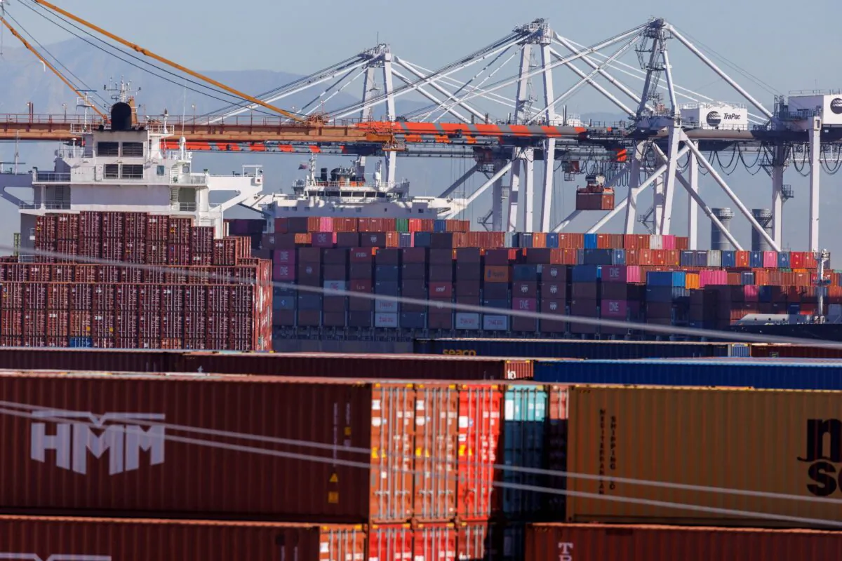 Stacked containers are shown as ships unload their cargo at the Port of Los Angeles in Los Angeles, Calif., on Nov. 22, 2021. (Mike Blake/Reuters)
