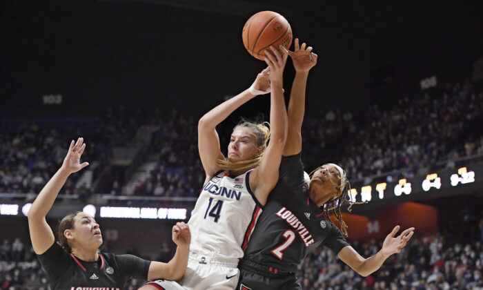 Connecticut's Dorka Juhasz (14) reaches up for a rebound against Louisville's Ahlana Smith (2) as Louisville's Mykasa Robinson (5) defends, during an NCAA college basketball game in Uncasville, Conn., on Dec. 19, 2021. (Jessica Hill/AP Photo)