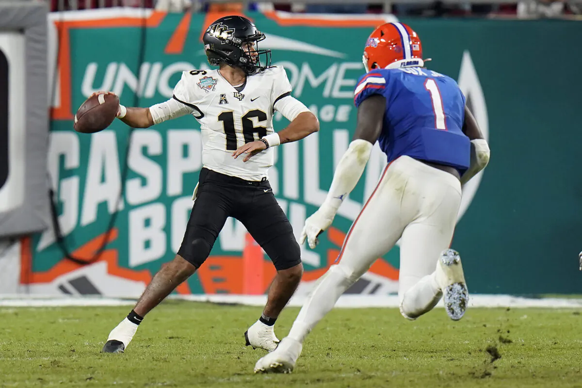 Central Florida quarterback Mikey Keene (16) throws a pass as he is pressured by Florida linebacker Brenton Cox Jr., during an NCAA college football game in Tampa, Fla., on Dec. 23, 2021.  (Chris O'Meara/AP Photo)