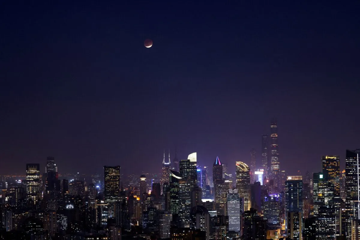 Lunar eclipse rises over the skyline of Shanghai, in China, on Nov. 19, 2021. (Aly Song/Reuters)