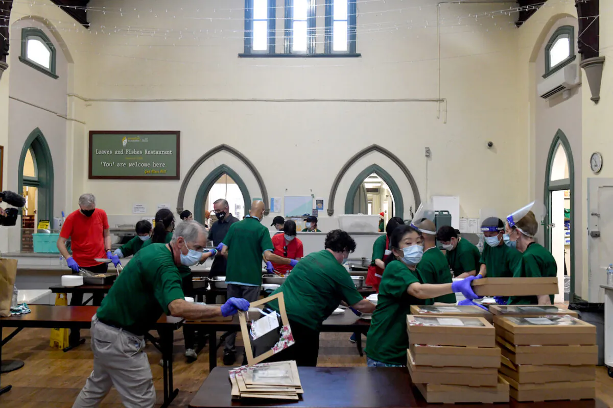 Volunteers prepare lunch packs at the Rev. Bill Crews Foundation Christmas lunch in Ashfield, Sydney, on Dec. 25, 2021. (AAP Image/Mick Tsikas)