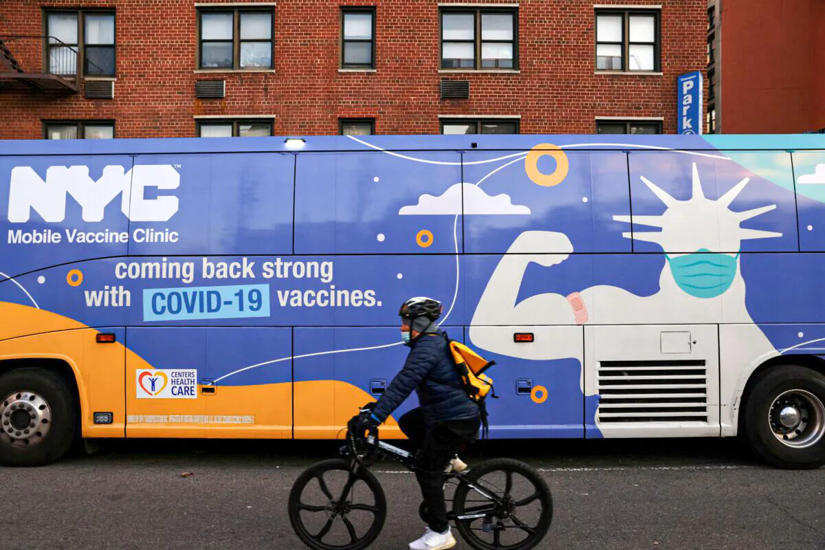 A person rides a bicycle past a mobile COVID-19 vaccine clinic in Manhattan, New York, on Dec. 7, 2021. (Andrew Kelly/Reuters)