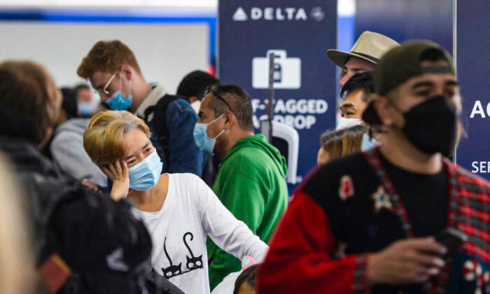 Travelers wait in line at Delta Airlines check-in at Los Angeles International Airport in Los Angeles, Calif., on Dec. 24, 2021. (David McNew/AFP via Getty Images)