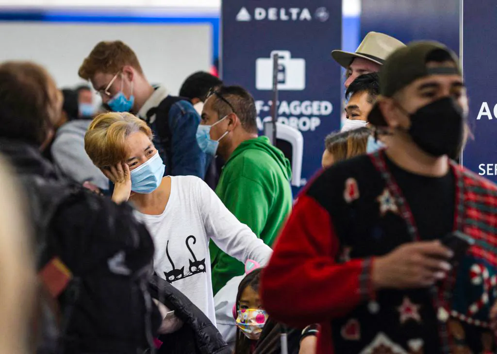Travelers wait in line at Delta Airlines check-in at Los Angeles International Airport in Los Angeles, on Dec. 24, 2021. (David McNew/AFP via Getty Images)