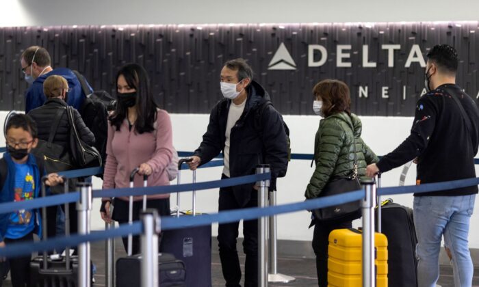 Travelers wait in line at Delta Airlines check-in at Los Angeles International Airport in Los Angeles, Calif., on Dec. 24, 2021. (David Mcnew/AFP via Getty Images)