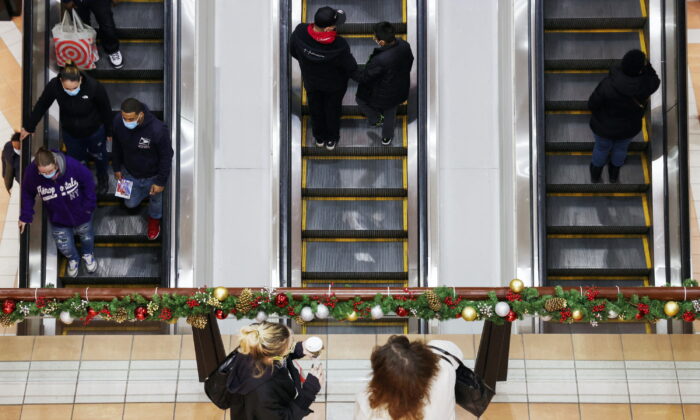 People ride an escalator while others stand at a mall in New York on Dec. 18, 2021. (Andrew Kelly/Reuters)