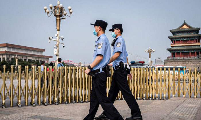 Police officers patrol an area outside Beijing's Tiananmen Square (back) on World Press Freedom Day on May 3, 2020. (Photo by NICOLAS ASFOURI / AFP) (Photo by NICOLAS ASFOURI/AFP via Getty Images)