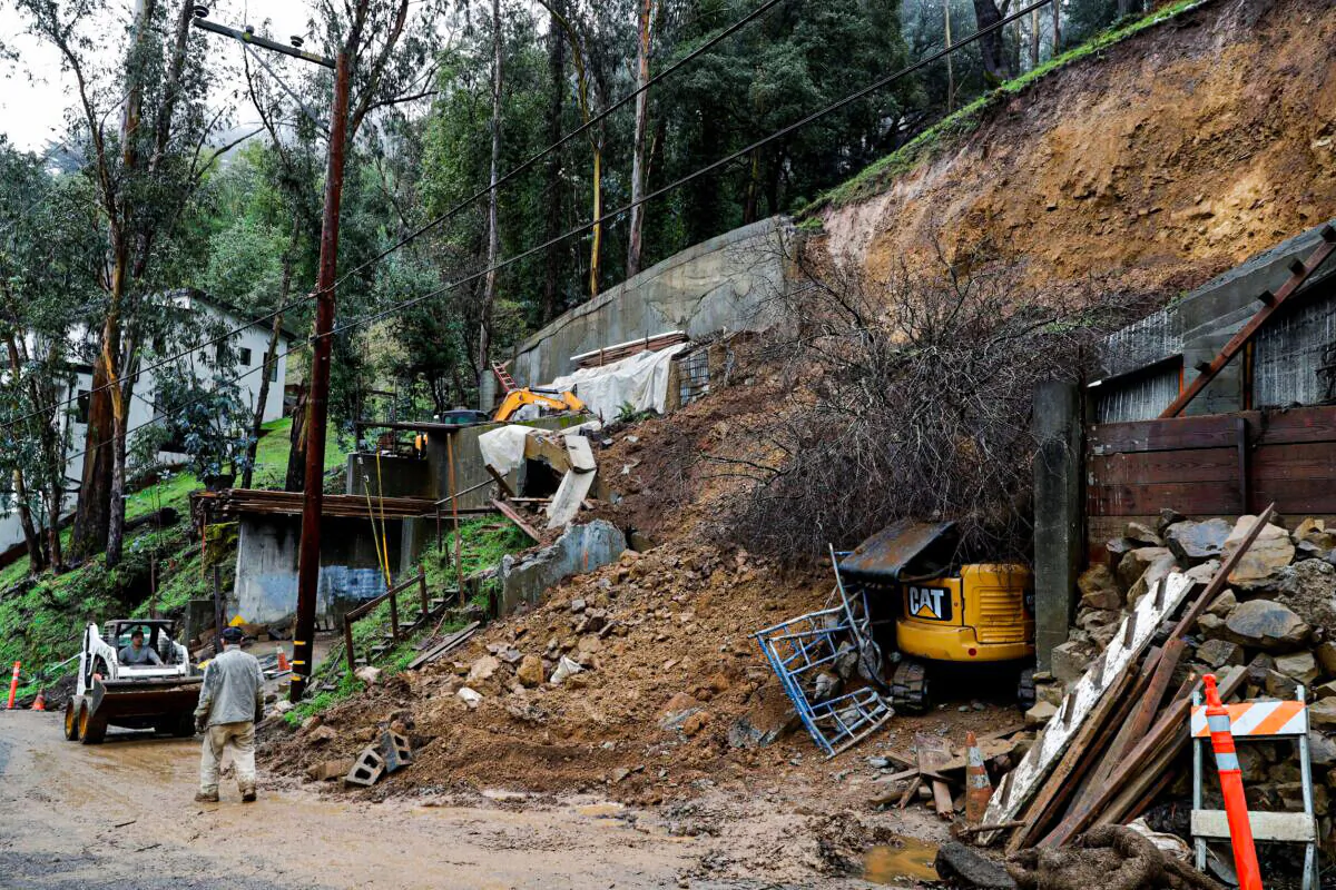 Workers clear a mudslide from a double lot on Westover Drive in Oakland, Calif., on Dec. 23, 2021. (Jane Tyska/Bay Area News Group via AP)