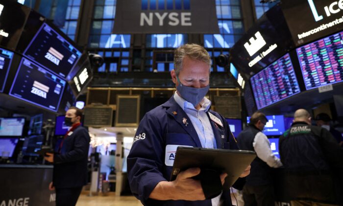 A trader works on the trading floor at the New York Stock Exchange (NYSE) as the Omicron coronavirus variant continues to spread in Manhattan, New York City, N.Y., on Dec. 20, 2021. (Andrew Kelly/Reuters)