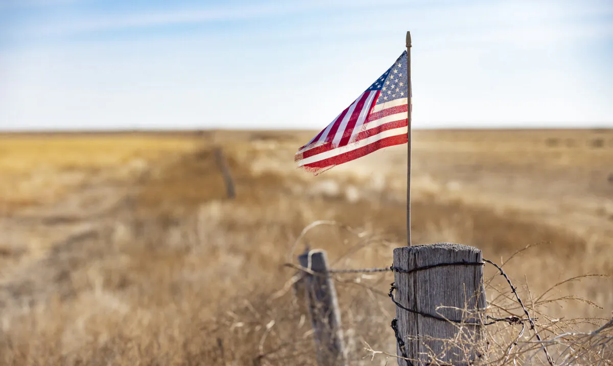An American flag blows in the wind on a fencepost in Southeastern Colorado on Dec. 6, 2021. (John Fredricks/The Epoch Times)