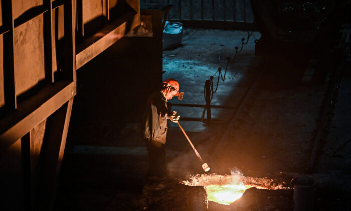 A worker extracts a sample of molten metal during a government organised tour at a Tiangong International plant, makers of high quality steel and tools, in  China's eastern Jiangsu Province on Oct. 12, 2020. (Hector Retamal/AFP via Getty Images)