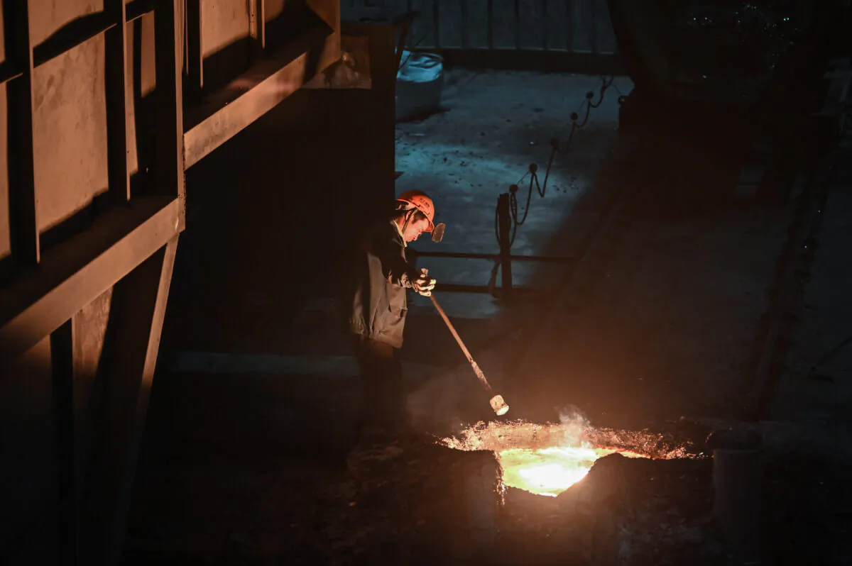 A worker extracts a sample of molten metal during a government organised tour at a Tiangong International plant, makers of high quality steel and tools, in  China's eastern Jiangsu Province on Oct. 12, 2020. (Hector Retamal/AFP via Getty Images)