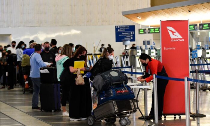 Travelers wait in line to verify their COVID-19 vaccination status as they check-in for a flight to Sydney, Australia on Qantas Airways Ltd. inside the Tom Bradley International Terminal at Los Angeles International Airport (LAX) in Los Angeles, Calif., on Nov. 1, 2021. (Patrick T. Fallon/AFP via Getty Images)