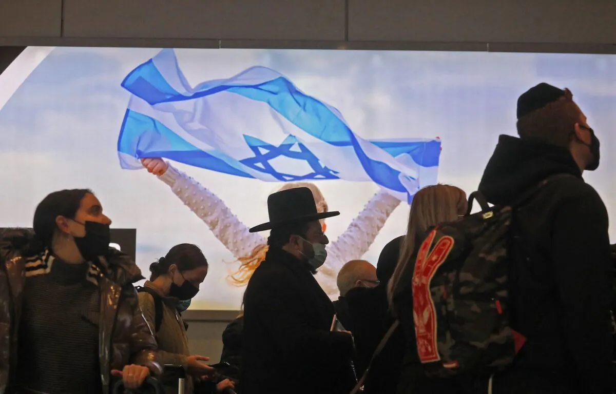 An ultra-Orthodox Jewish traveler waits in queue with other travellers with luggage at the check-in counter ahead of their departing flights at Israel's Ben Gurion Airport in Lod, east of Tel Aviv, on Dec. 21, 2021. (Gil Cohen-Magen/AFP via Getty Images)