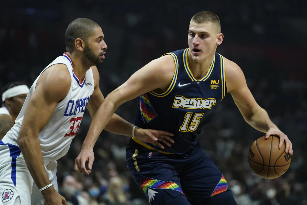 Los Angeles Clippers forward Nicolas Batum (33) defends against Denver Nuggets center Nikola Jokic (15) during the first half of an NBA basketball game in Los Angeles on Dec. 26, 2021. (AP Photo/Ashley Landis)