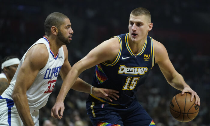 Los Angeles Clippers forward Nicolas Batum (33) defends against Denver Nuggets center Nikola Jokic (15) during the first half of an NBA basketball game in Los Angeles on Dec. 26, 2021. (AP Photo/Ashley Landis)