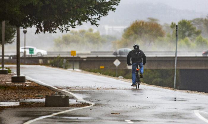 A man rides a bicycle along  the San Diego Creek in Irvine, Calif., on Dec. 14, 2021. (John Fredricks/The Epoch Times)