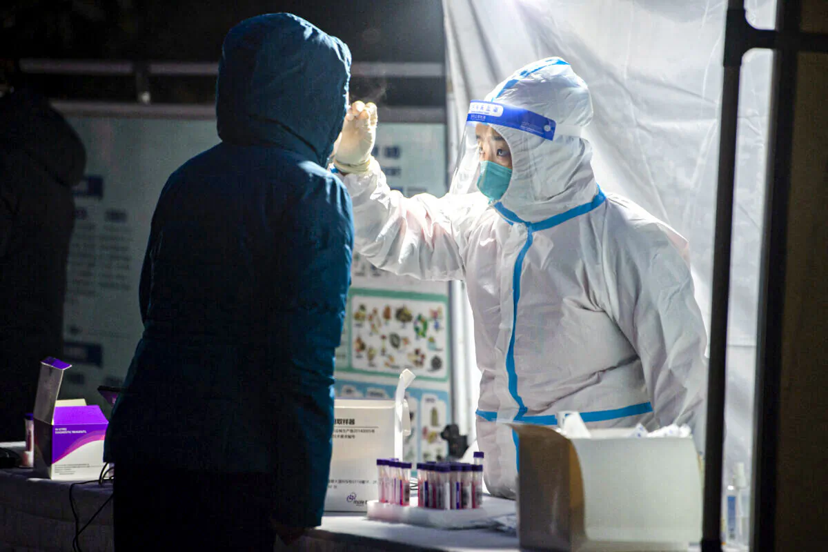 A medical worker is taking a swab sample from a resident to be tested for the COVID-19 coronavirus in Xi'an city, Shaanxi Province, China, on Dec. 25, 2021. (STR/AFP via Getty Images)