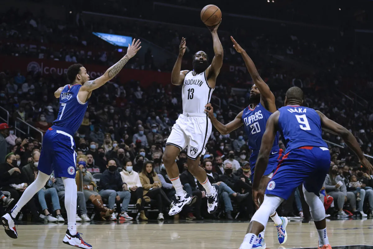 Brooklyn Nets' James Harden, center, shoots under pressure by Los Angeles Clippers' Amir Coffey, left, and Justise Winslow during first half of an NBA basketball game in Los Angeles on Dec. 27, 2021. (AP Photo/Jae C. Hong)