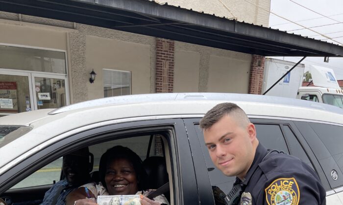 Officer J. Zaino of the Ocala Police Department in Florida surprises a woman he pulled over for a problem with her brake lights by giving her $100 as part of Operation Secret Santa 2021. (Courtesy of Ocala Police Department)

