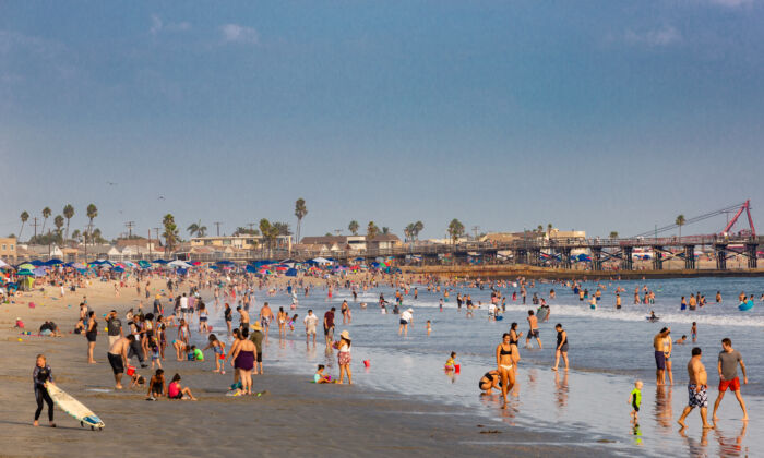Beachgoers enjoy cooling off in the ocean in Seal Beach, Calif., on Sept. 6, 2020. (John Fredricks/The Epoch Times)