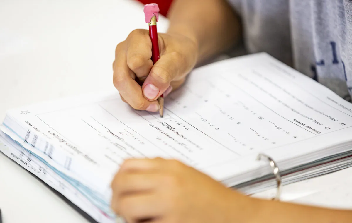 Elementary aged students work on their math homework in Laguna Niguel, Calif., on May 12, 2021. (John Fredricks/The Epoch Times)