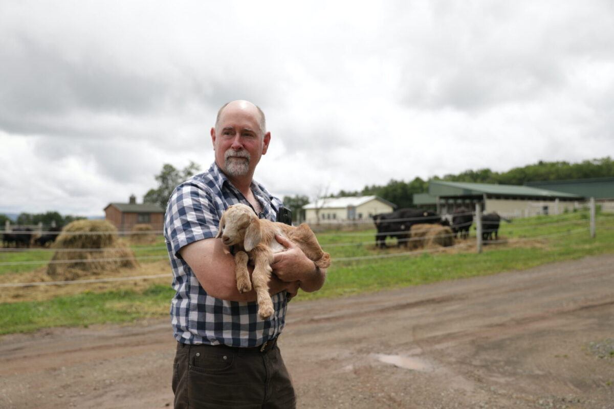 Farmer Patrick Rider with a newborn baby goat. (Photo by Lux Aeterna Photography)