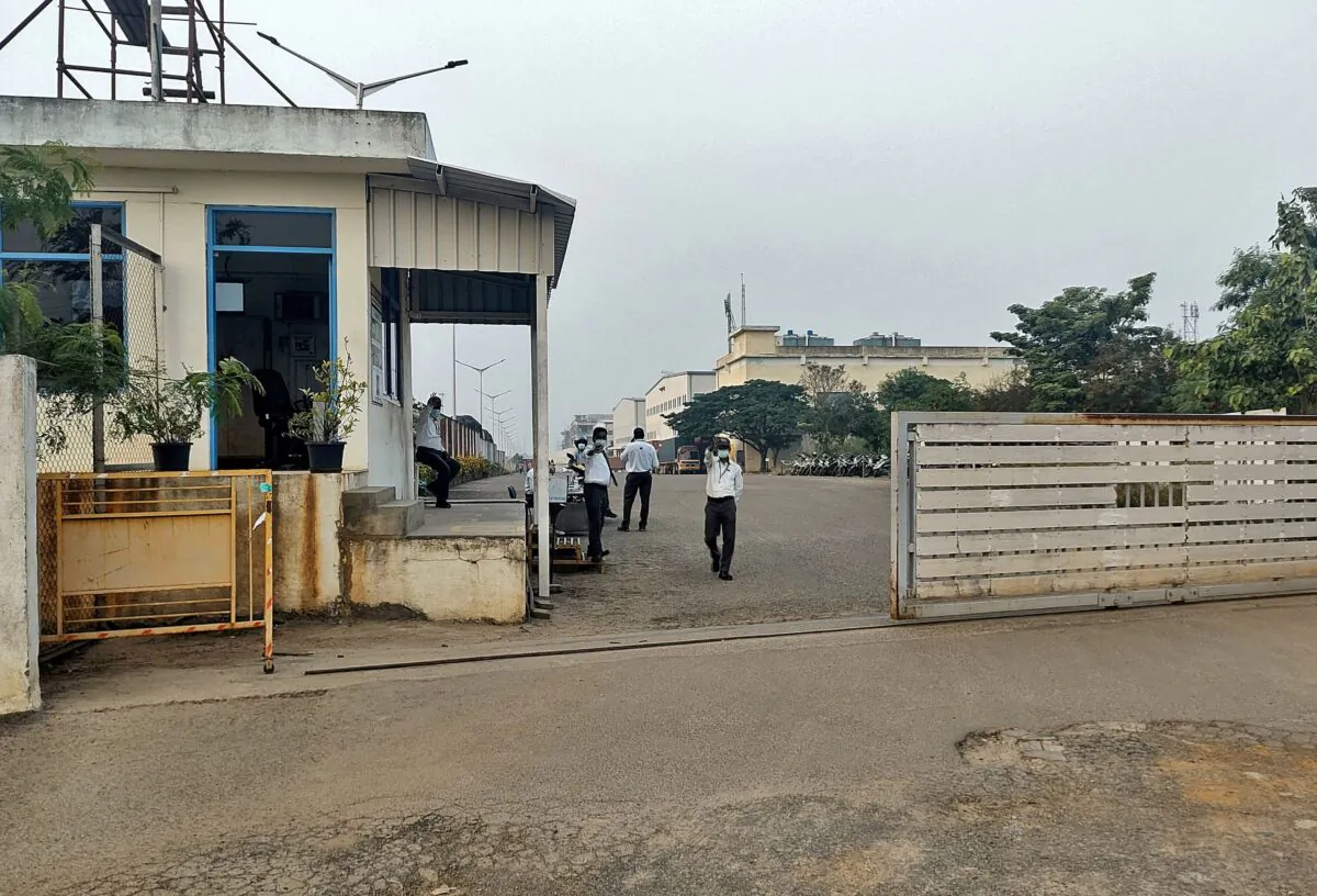 Men ride their motorbikes past a closed plant of Foxconn India unit, which makes iPhones for Apple Inc, near Chennai, India, on Dec. 21, 2021. (Sudarshan Varadhan/ Reuters)