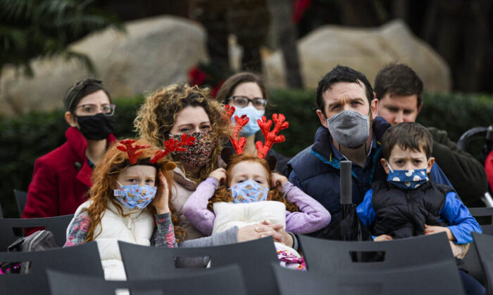 A family wears protective masks in Garden Grove, Calif. on Dec. 24, 2020. (Patrick T. Fallon / AFP via Getty Images)