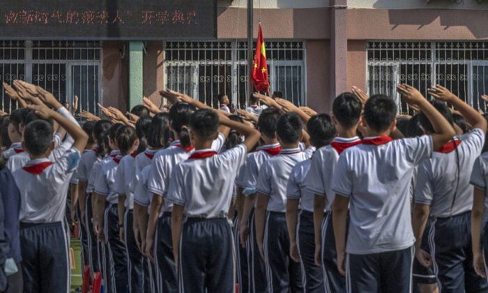 Students salute as a national flag is raised during a ceremony on the first day of the new school year at an elementary school on September 1, 2021 in Beijing, China.  (Kevin Frayer/Getty Images)