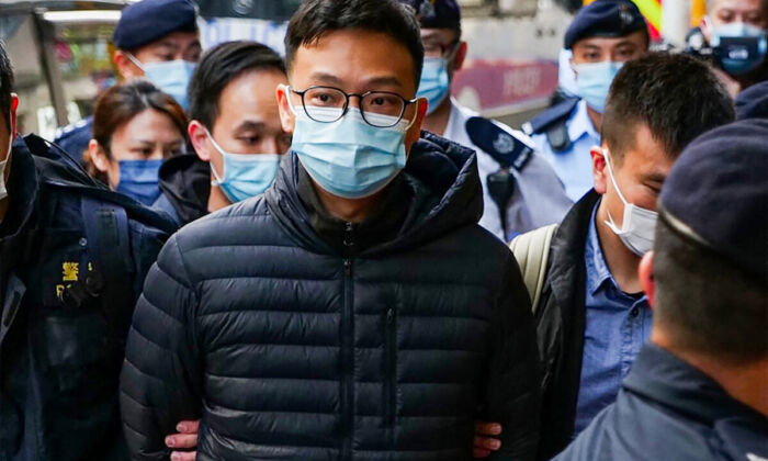 Stand News chief editor Patrick Lam is brought to the news outlet's office building in handcuffs after police were deployed to search the premises in Hong Kong's Kwun Tong district on Dec 29, 2021. (Daniel Suen/AFP via Getty Images)