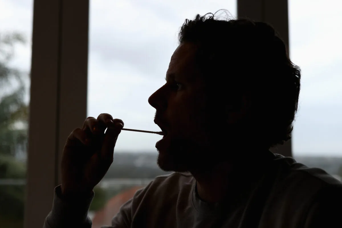 A man uses a COVID-19 rapid antigen test kit at home in Sydney, Australia, on Sept. 29, 2021. (Cameron Spencer/Getty Images)