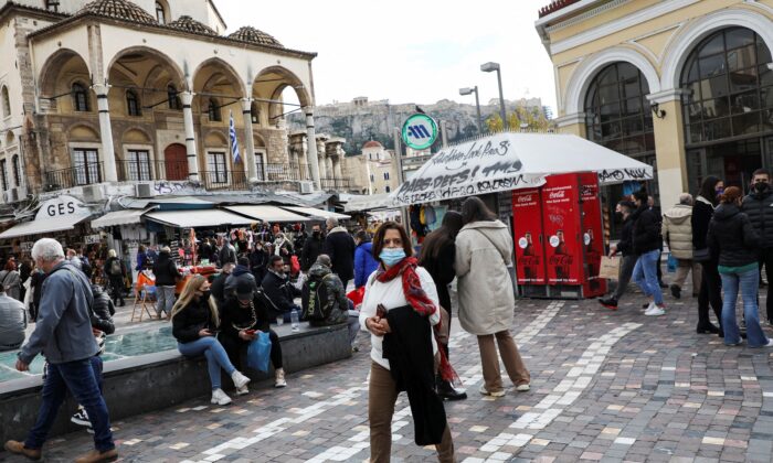 People wearing protective face masks make their way to Monastiraki square in Athens, Greece, on Dec. 29, 2021. (Louiza Vradi/Reuters)