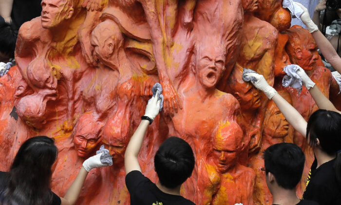 University students clean the "Pillar of Shame" statue, a memorial for those killed in the 1989 Tiananmen crackdown, at the University of Hong Kong, on June 4, 2019. (Kin Cheung/AP Photo)
