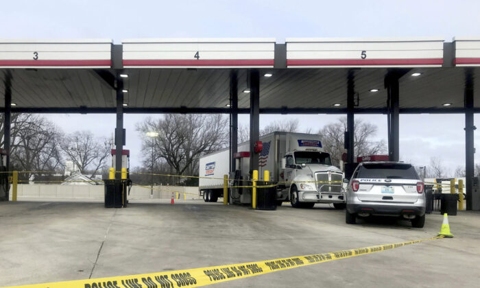 A tractor trailer is stopped behind police tape as law enforcement investigate the scene of a carjacking and shooting at a QuikTrip in St. Peters, Mo., on Dec. 29, 2021. (Hillary Levin/St. Louis Post-Dispatch via AP)