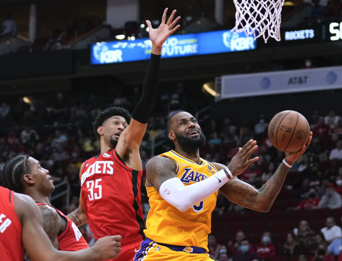 Los Angeles Lakers forward LeBron James, right, shoots as Houston Rockets center Christian Wood (35) defends during the first half of an NBA basketball game in Houston on Dec. 28, 2021. (AP Photo/Eric Christian Smith)