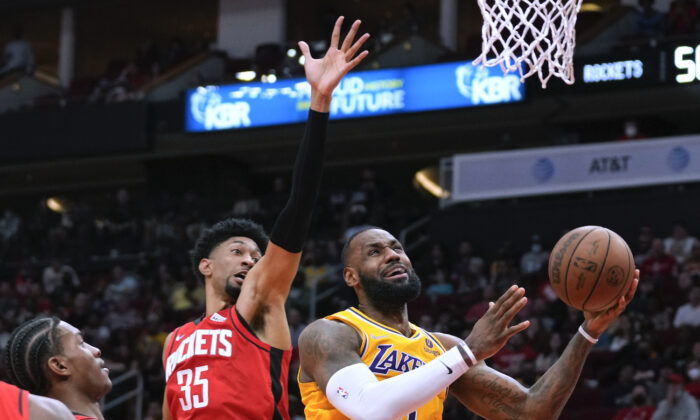 Los Angeles Lakers forward LeBron James, right, shoots as Houston Rockets center Christian Wood (35) defends during the first half of an NBA basketball game in Houston on Dec. 28, 2021. (AP Photo/Eric Christian Smith)