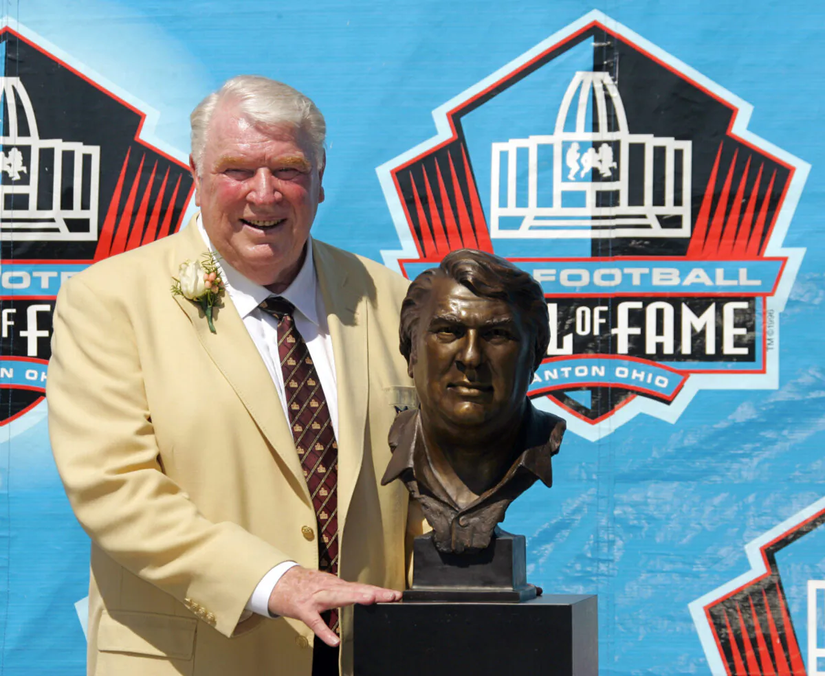 Broadcaster and former Oakland Raiders coach John Madden poses with his bust after enshrinement into the Pro Football Hall of Fame, in Canton, Ohio, on Aug. 5, 2006. (Mark Duncan/AP Photo)