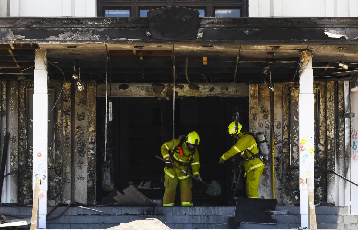 Fire fighters are seen entering the fire damaged entrance to Old Parliament House in Canberra, Australia, on Dec. 30, 2021. (AAP Image/Lukas Coch) 