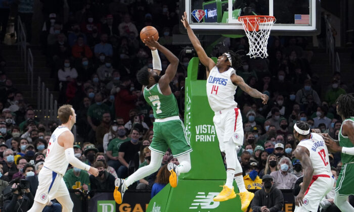 Boston Celtics guard Jaylen Brown (7) shoots over Los Angeles Clippers guard Terance Mann (14) during the first half of an NBA basketball game in Boston on Dec. 29, 2021. (AP Photo/Mary Schwalm)