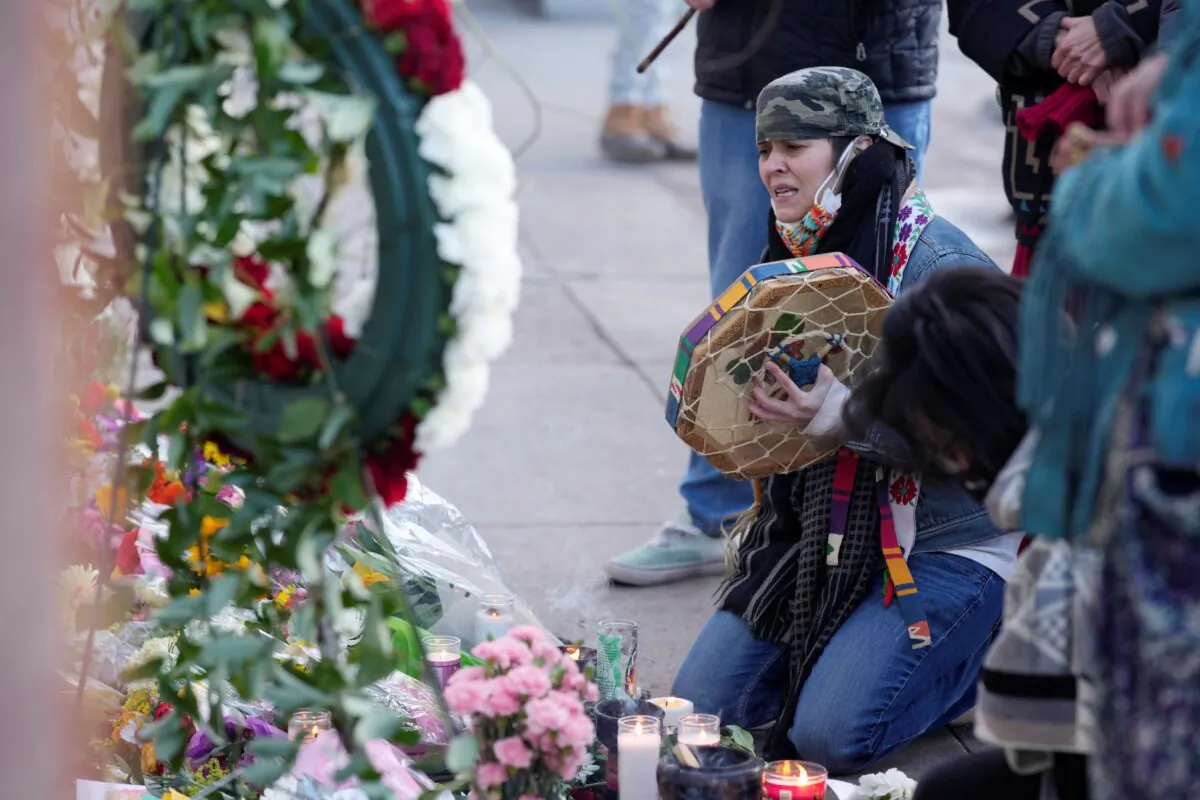 Mourners gather outside the door of a tattoo parlor along South Broadway in Denver, on Dec. 28, 2021. (David Zalubowski/AP Photo)