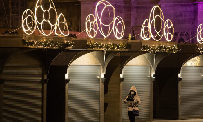 A person walks past closed Christmas market stalls on Stephansplatz on the third day of a nationwide, temporary lockdown during the fourth wave of the novel coronavirus pandemic on Nov. 24, 2021, in Vienna, Austria. (Thomas Kronsteiner/Getty Images)