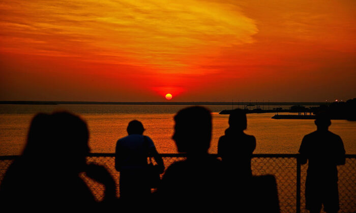 People watch the sunset over Port Darwin from Bicentennial Park on October 6, 2013 in Darwin, Australia. (Scott Barbour/Getty Images)